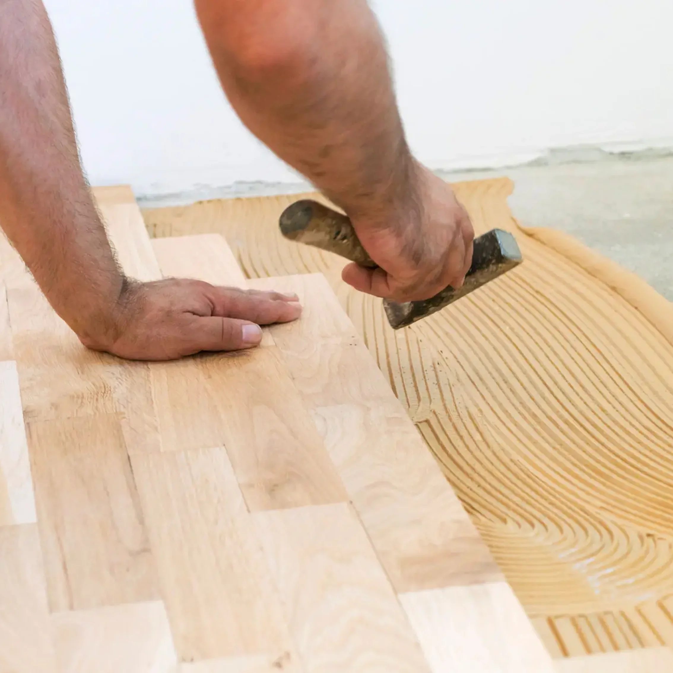 Technician completing hardwood floor restoration inside a home in Phoenix.
